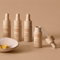 Four bottles of the Divine Ritual™ mask boosters, with one bottle open with dropper leaning on the side