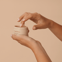 woman's hand dipping into Divine Ritual™ Balm jar